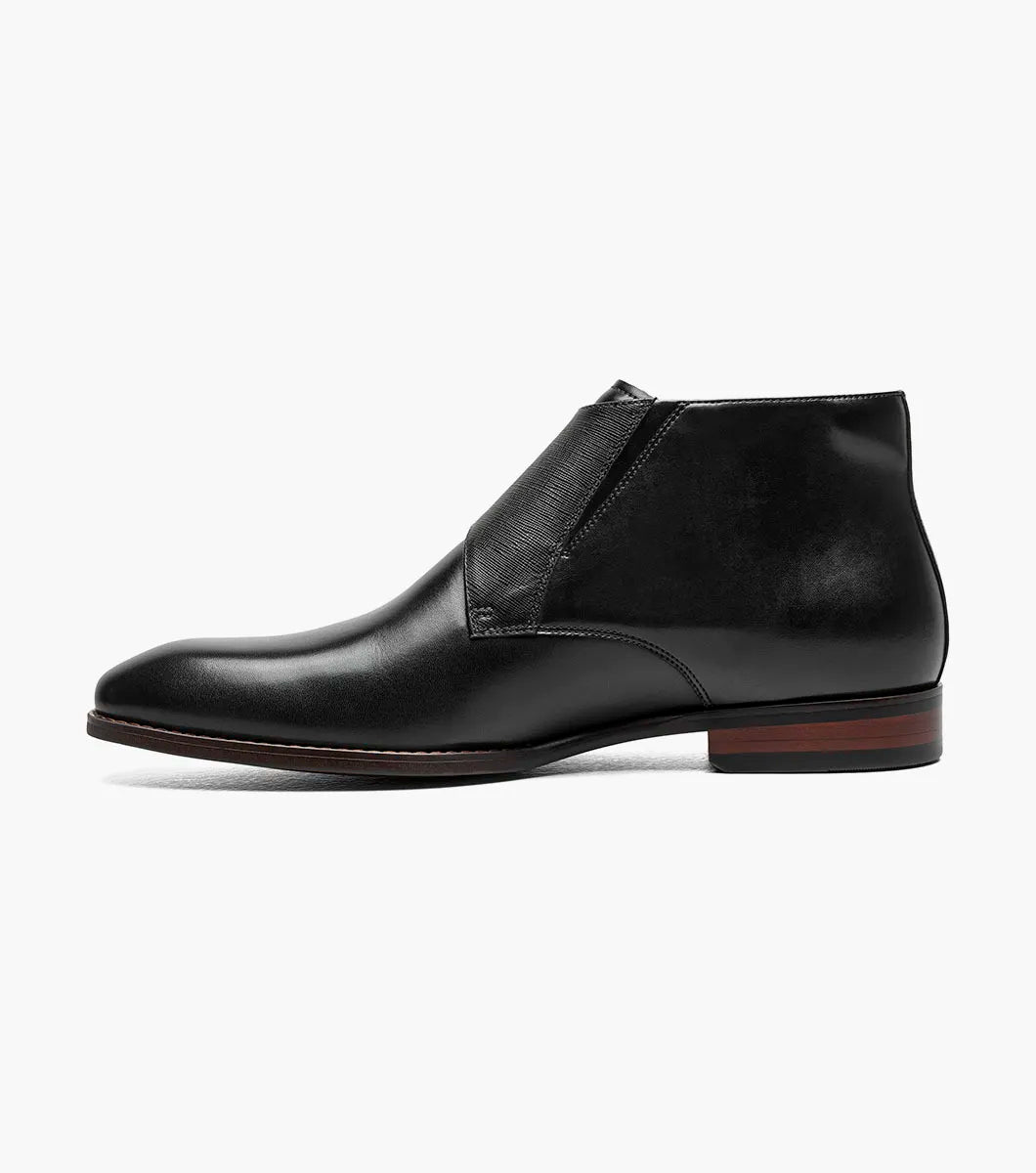 The STACY ADAMS Kaius Plain Toe Double Monk Strap Boot (25733-001) features a black leather upper, silver buckles, low stacked heel, anatomical arch support, and a patterned inner lining.