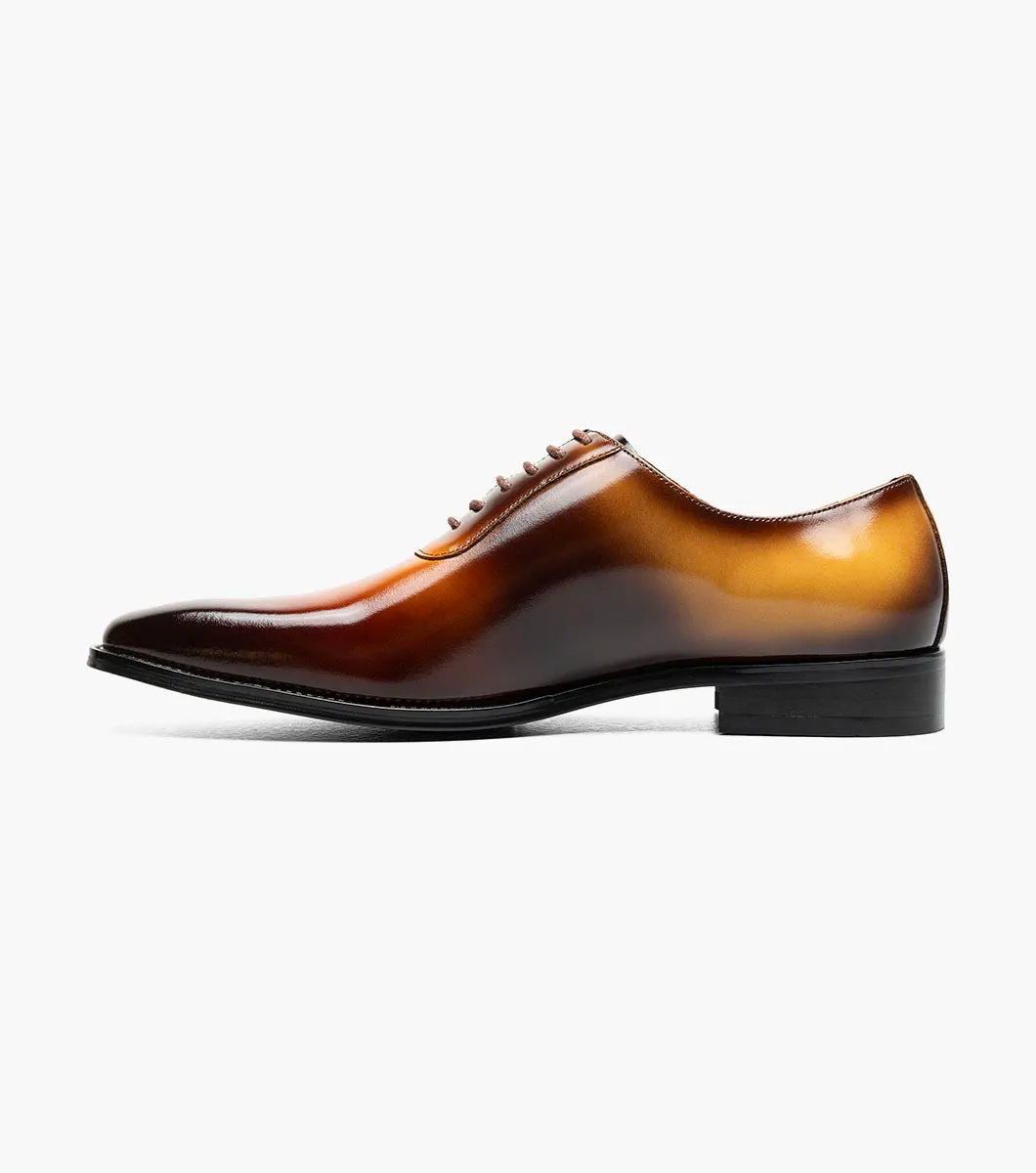 The STACY ADAMS Shaffer Plain Toe Oxford in Cognac Multi (25763-229) features calf leather with a brown-yellow gradient, laces, a low heel, memory foam insole, and polished finish, displayed on a white background.