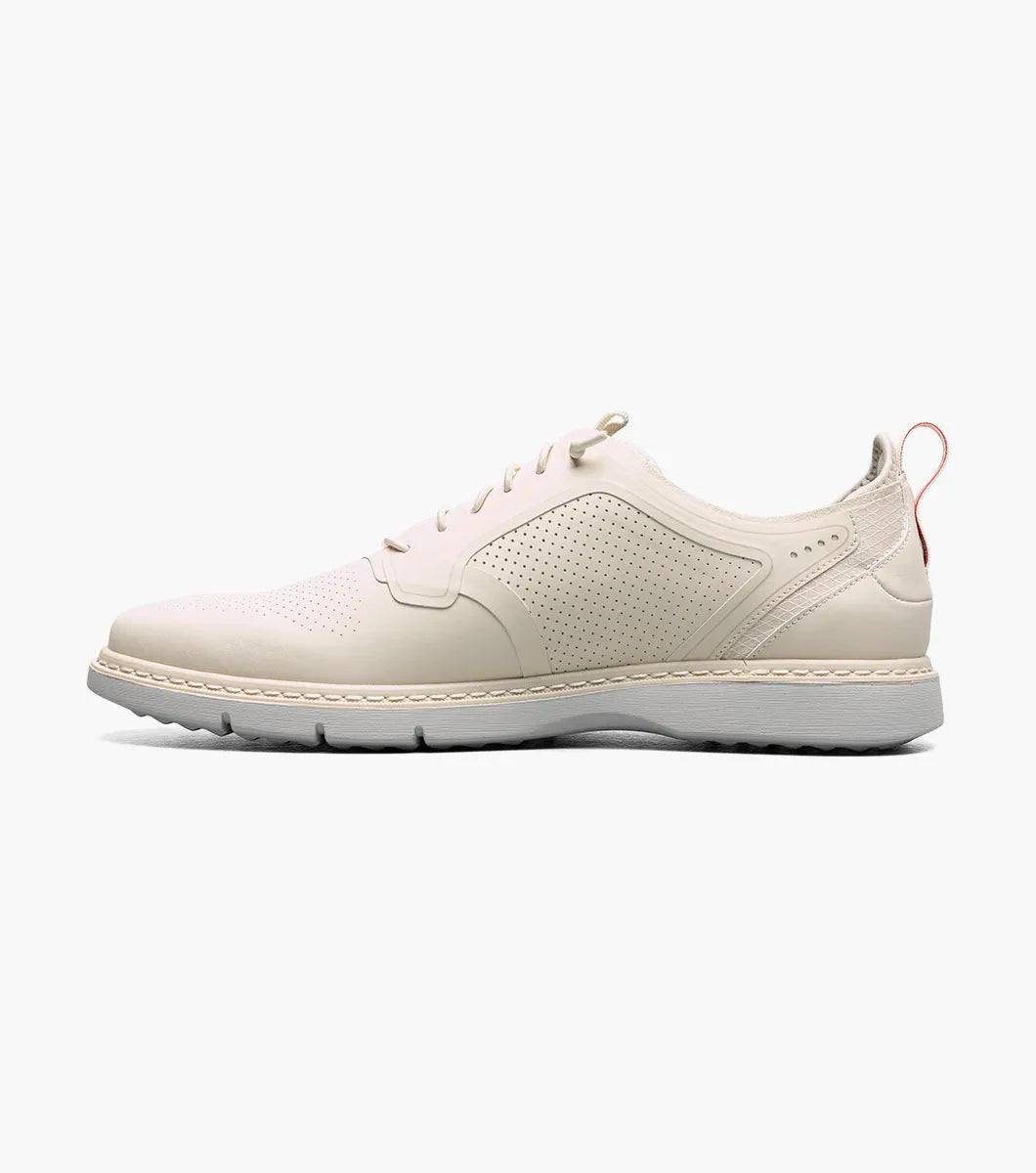 The STACY ADAMS Synchro Plain Toe Elastic Lace Up in cream (25518-113) is a leather dress shoe with perforated detailing, a gray sole, elastic laces, and a red heel pull tab, shown on a white background.