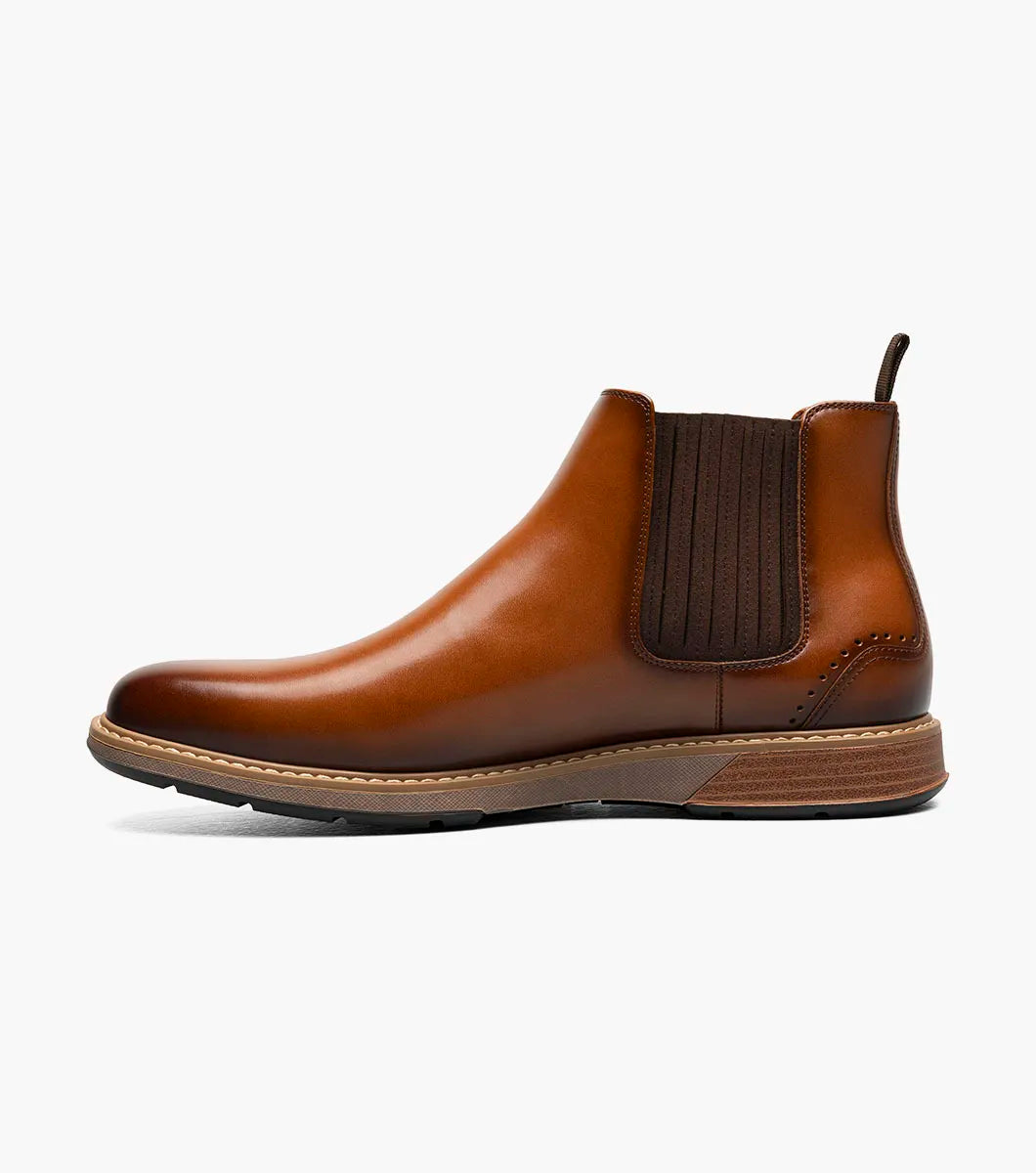 The Stacy Adams Platt Plain Toe Chelsea Boot in cognac features elastic side panels, a back pull tab, low stacked heel, and a RedZone removable footbed; shown on a white background.