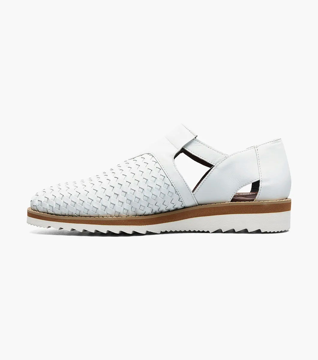 The Stacy Adams Alvarado Woven City Sandal in white features a woven leather upper, buckle strap, brown sole, white serrated outsole, and a soft memory foam insole for comfort. Displayed on a white background.