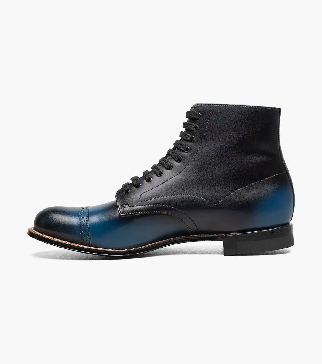 The STACY ADAMS Madison Cap Toe Lace Up Boot in blue (00110-400) is a leather dress boot with a cap toe and brogue detailing, displayed on a white background.