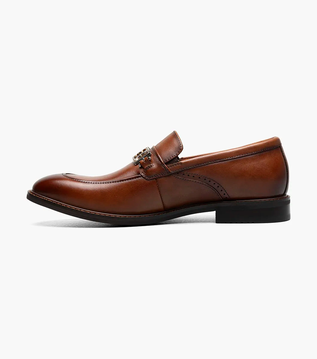 The Stacy Adams Boyd Moc Toe Bit Slip On in Brandy features a brown leather upper, moc toe design, metal horsebit detail, low heel, cushioned footbed, and visible stitching. Model 25753-226 by STACY ADAMS shown on a white background.