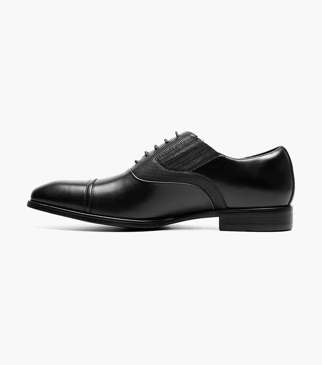 The STACY ADAMS Lucas Cap Toe Oxford (25766-001) is a black leather men's dress shoe with textured side panels, black laces, and a supportive RedZone footbed, shown on a plain white background.