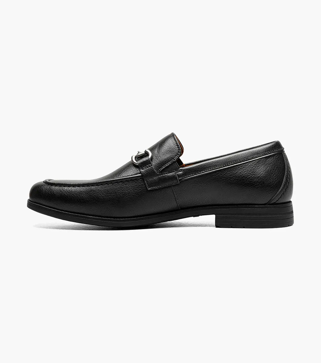 The STACY ADAMS Richmont Moc Toe Bit Slip On in Black Tumbled (21567-007) features black leather, a metal bit detail, low heel, and brown lining—shown here as a stylish dress casual loafer on a white background.