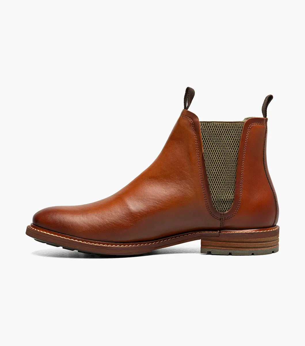 The Stacy Adams Isaacson Plain Toe Chelsea Boot in Cognac features elastic side panels, pull tabs, a low stacked heel, and a supportive leather upper—all displayed on a white background.