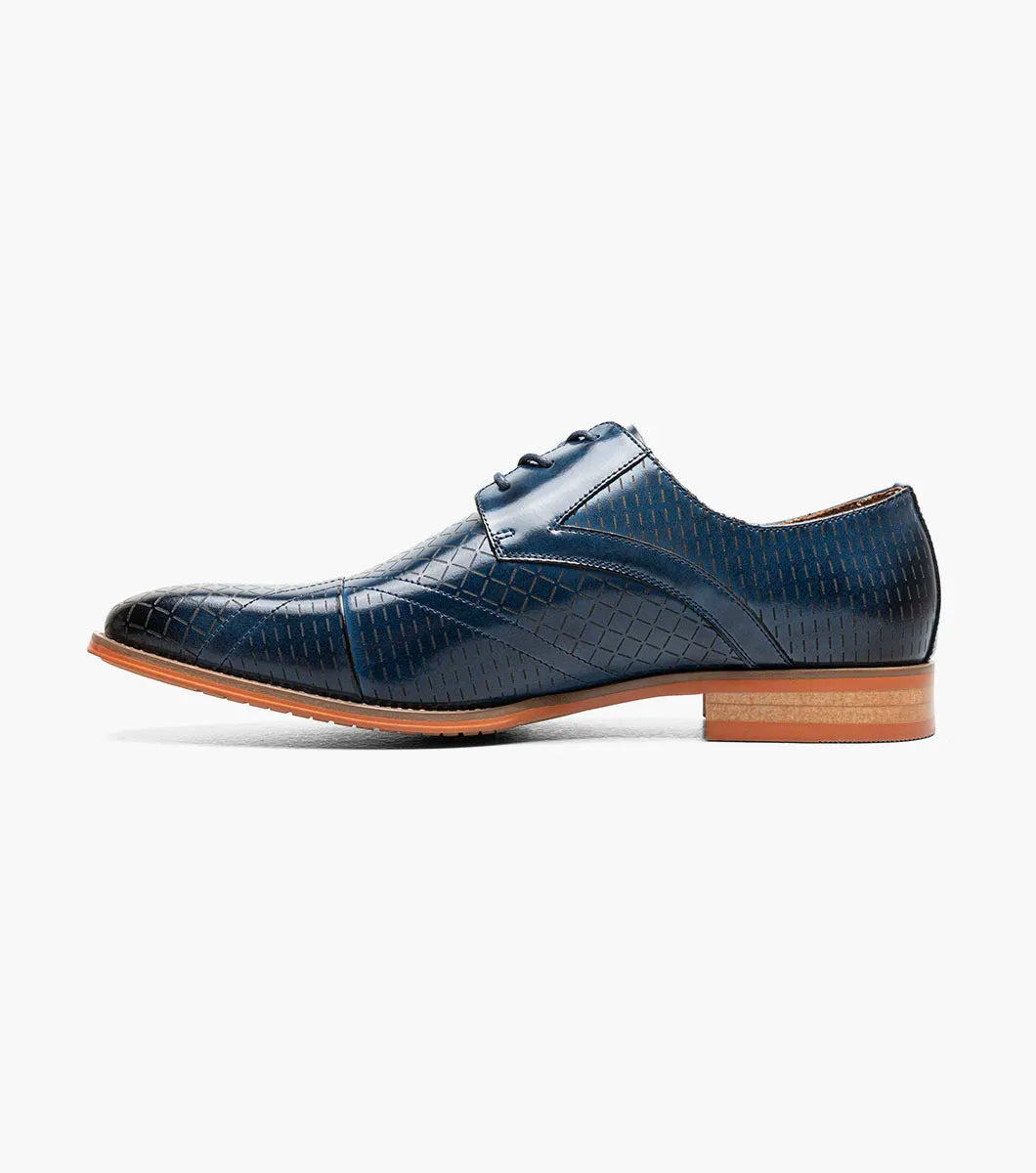 The Stacy Adams Hobson Cap Toe Oxford (25764-400) is a single blue dress shoe with a laser-etched diamond calf leather pattern, lace-up closure, brown sole, and sleek pointed toe.