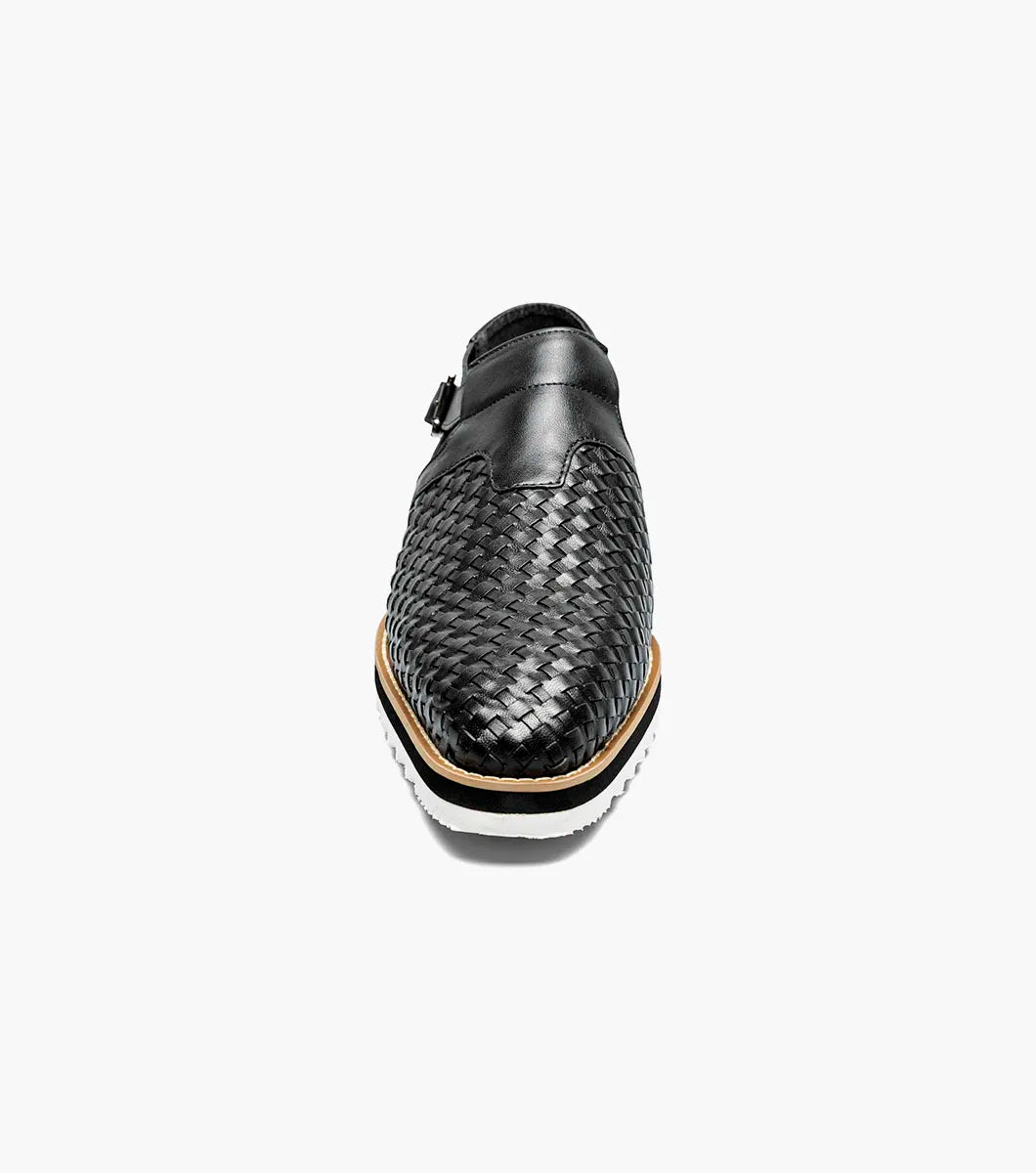The Stacy Adams Alvarado Woven City Sandal features a black woven leather upper, buckle strap, closed toe, memory foam insole, and a white ridged sole with tan accent.
