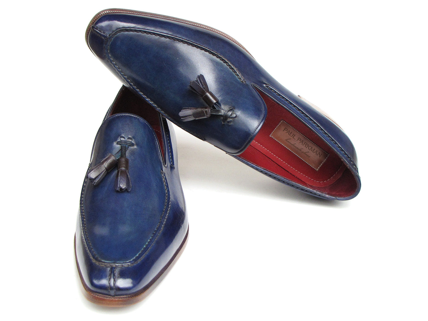 The Paul Parkman Tassel Loafer Blue Hand Painted Leather - 083-BLU is a men's slip-on shoe with blue hand-painted leather, brown soles, and a striking red inner lining, shown on a white background.