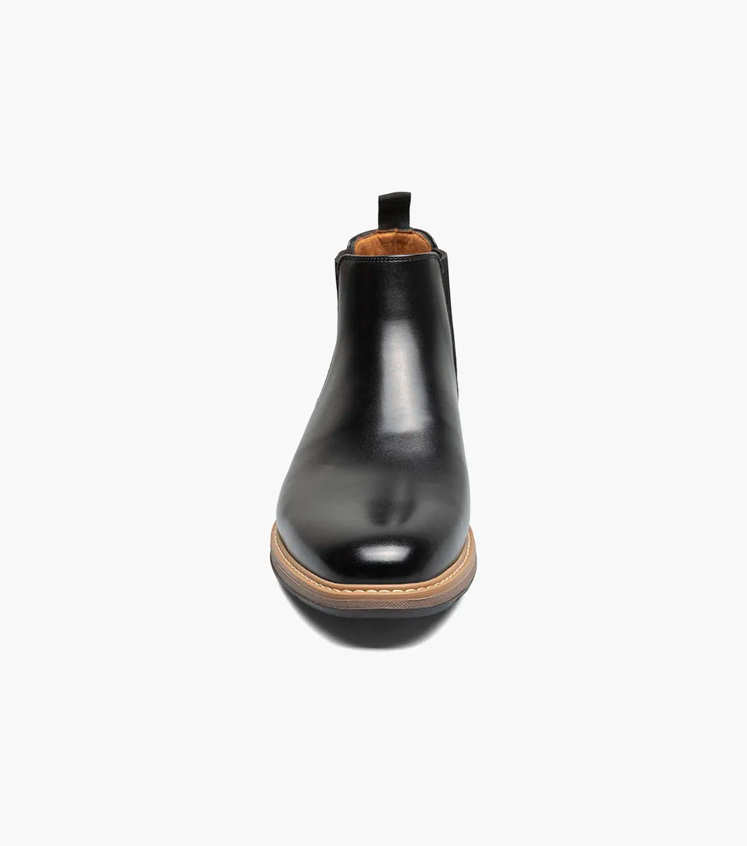 The STACY ADAMS Platt Plain Toe Chelsea Boot (Black, 25755-001) features sleek leather, elastic side panels, a brown sole, and a back pull tab—an elegant choice for any men’s boot collection.