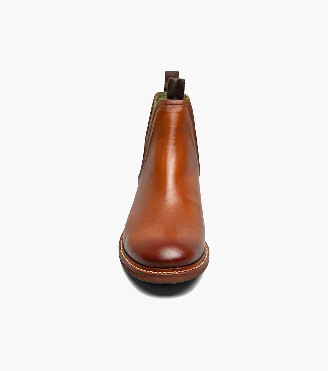 The Stacy Adams Isaacson Plain Toe Chelsea Boot in Cognac features elastic side panels, pull tabs, a low stacked heel, and a supportive leather upper—all displayed on a white background.
