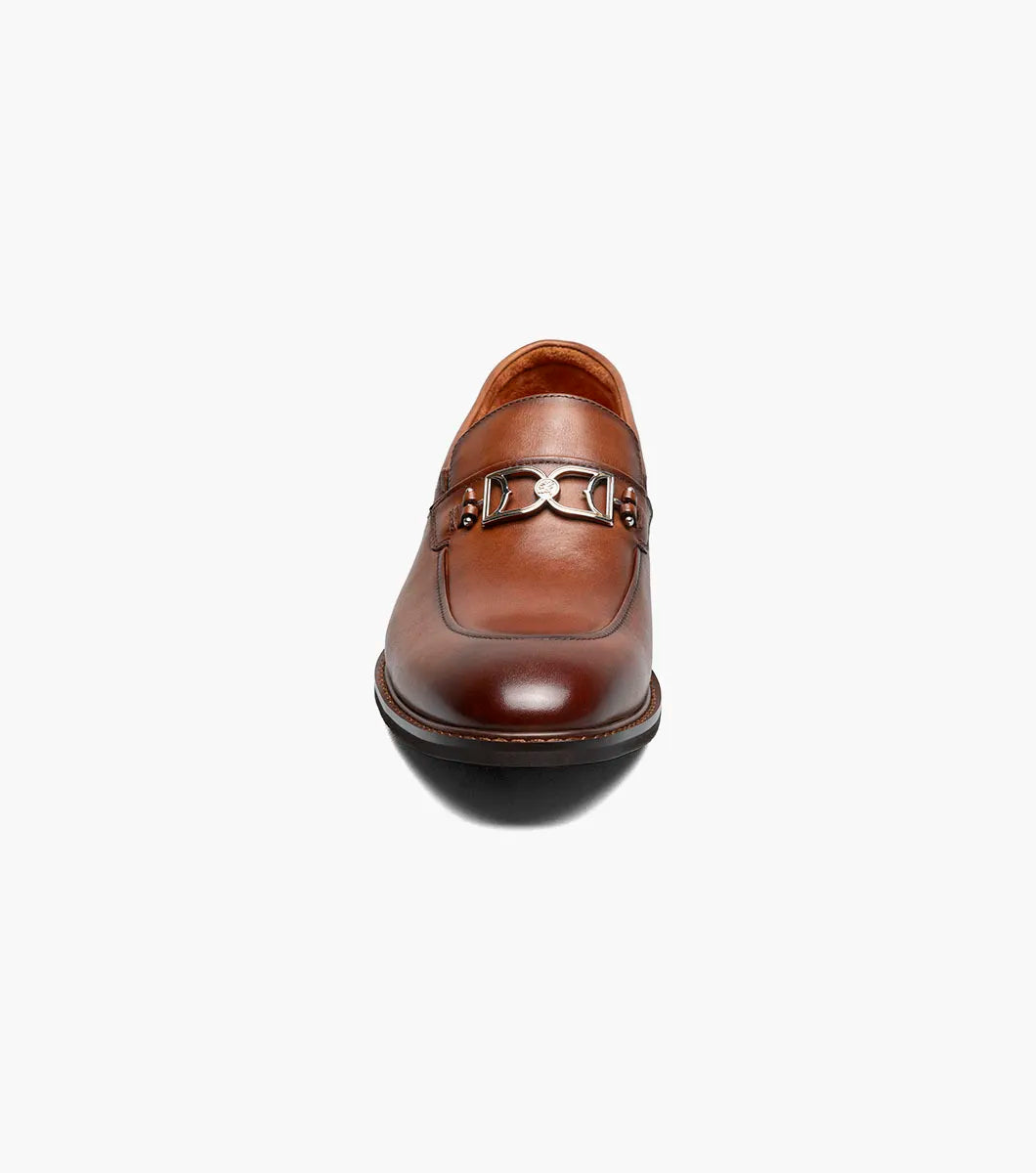 The Stacy Adams Boyd Moc Toe Bit Slip On in Brandy features a brown leather upper, moc toe design, metal horsebit detail, low heel, cushioned footbed, and visible stitching. Model 25753-226 by STACY ADAMS shown on a white background.