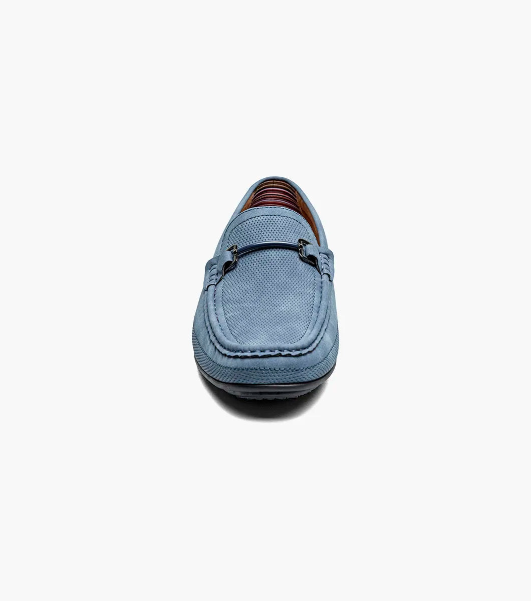 The STACY ADAMS Colton Moc Toe Bit Slip On (Navy, 25760-410) features a cushioned footbed, metal bit detail, moc toe stitching, and a flat black sole, shown on a white background.