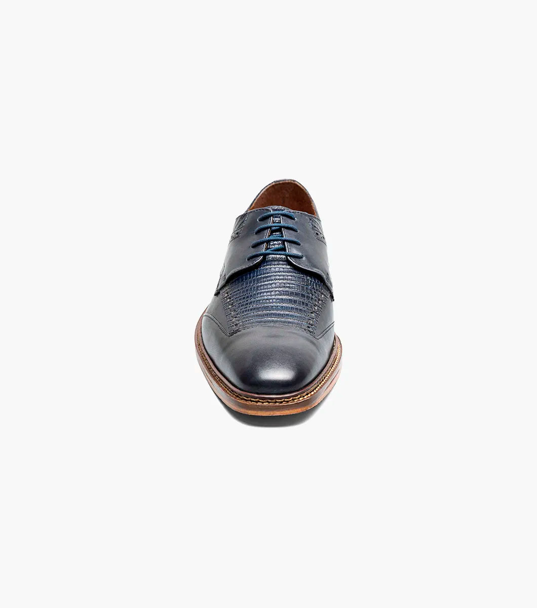 The STACY ADAMS Gambetta Modified Cap Toe Oxford (Navy, 25780-410) is a navy blue leather dress shoe featuring a textured pattern, brown sole, RedZone footbed, and lace-up closure, displayed on a white background.