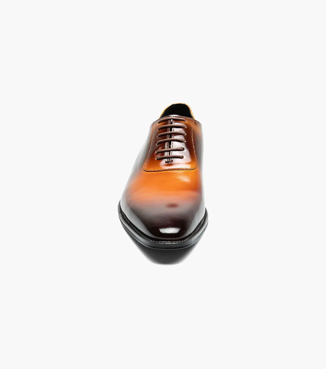The STACY ADAMS Shaffer Plain Toe Oxford in Cognac Multi (25763-229) features calf leather with a brown-yellow gradient, laces, a low heel, memory foam insole, and polished finish, displayed on a white background.