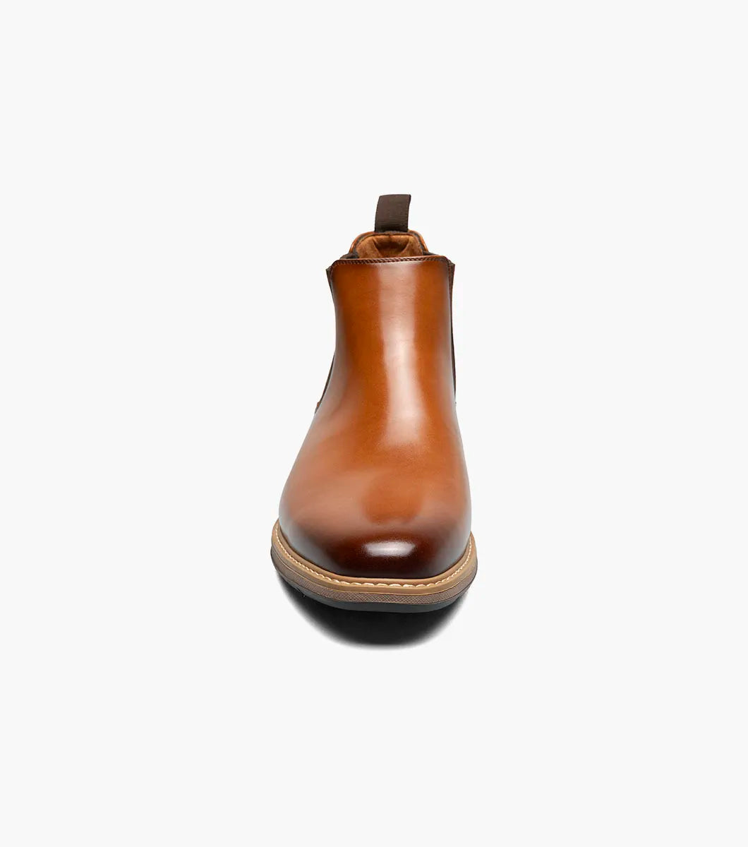 The Stacy Adams Platt Plain Toe Chelsea Boot in cognac features elastic side panels, a back pull tab, low stacked heel, and a RedZone removable footbed; shown on a white background.