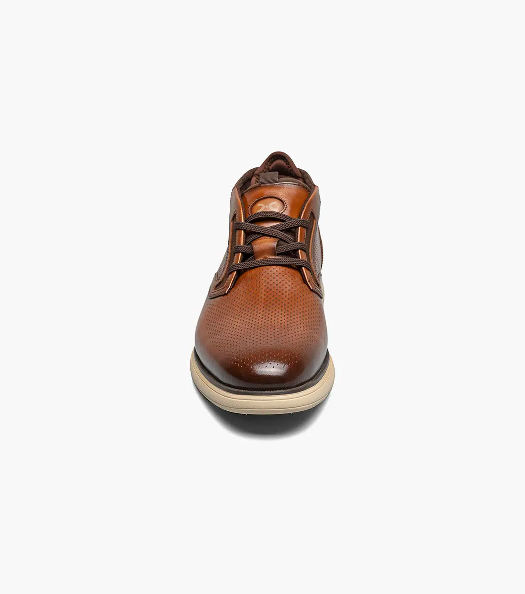 The Stacy Adams Eastmont Plain Toe Elastic Lace Chukka Boot in cognac features a perforated design, light tan rubber sole, and anatomical arch support for all-day comfort, shown on a white background.