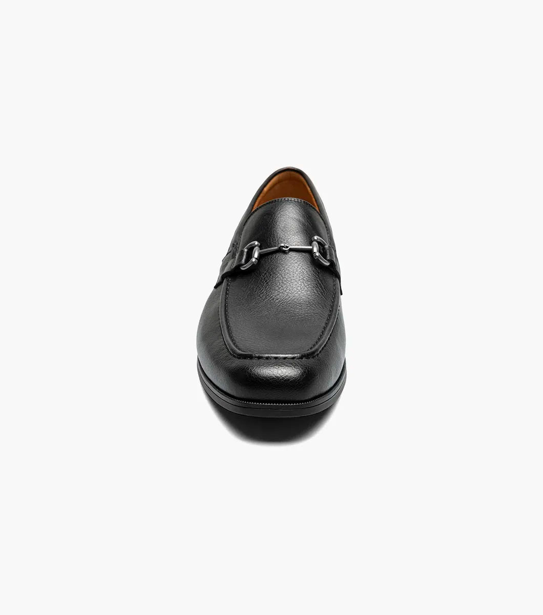 The STACY ADAMS Richmont Moc Toe Bit Slip On in Black Tumbled (21567-007) features black leather, a metal bit detail, low heel, and brown lining—shown here as a stylish dress casual loafer on a white background.