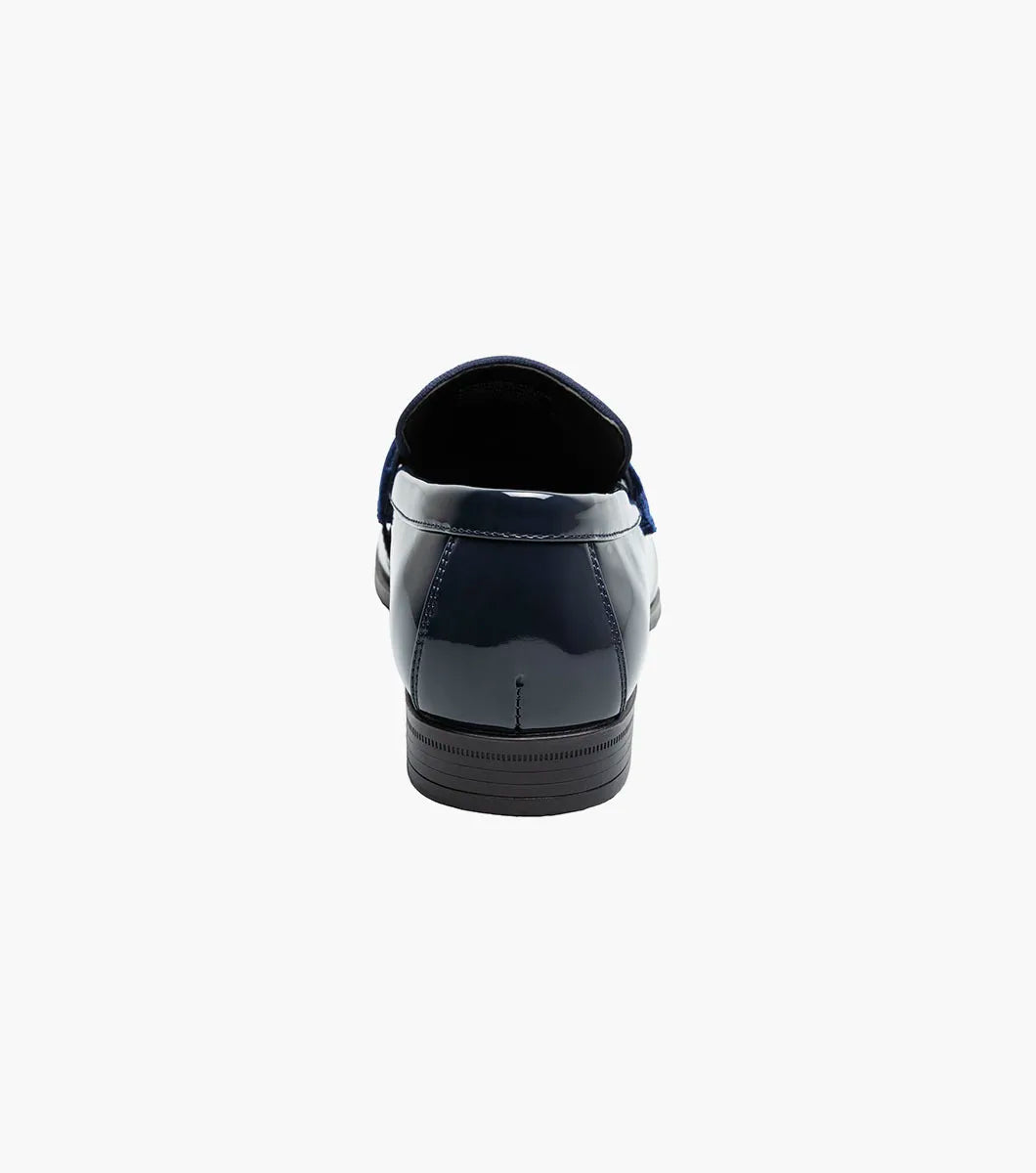 The Stacy Adams Spratley Moc Toe Saddle Slip On (25686-410) features shiny navy blue leather, a matching velour upper, cushioned insole, and low black heel. Displayed solo on a white background.