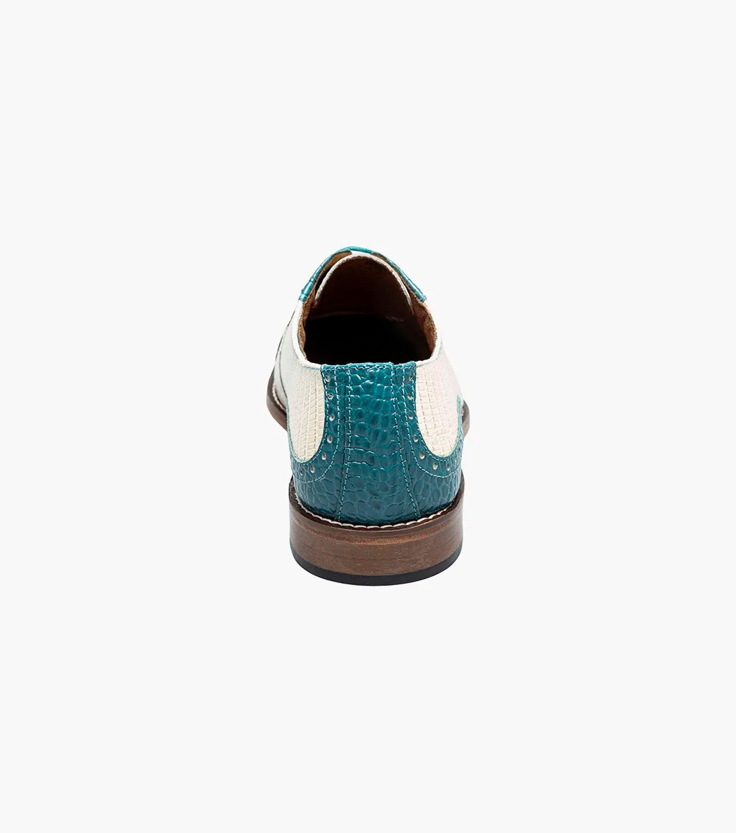 The STACY ADAMS Tarango Modified Cap Toe Oxford (25770-448) is a men's formal shoe in navy with teal, showcasing crocodile print leather and a laceless design, pictured on a plain white background.