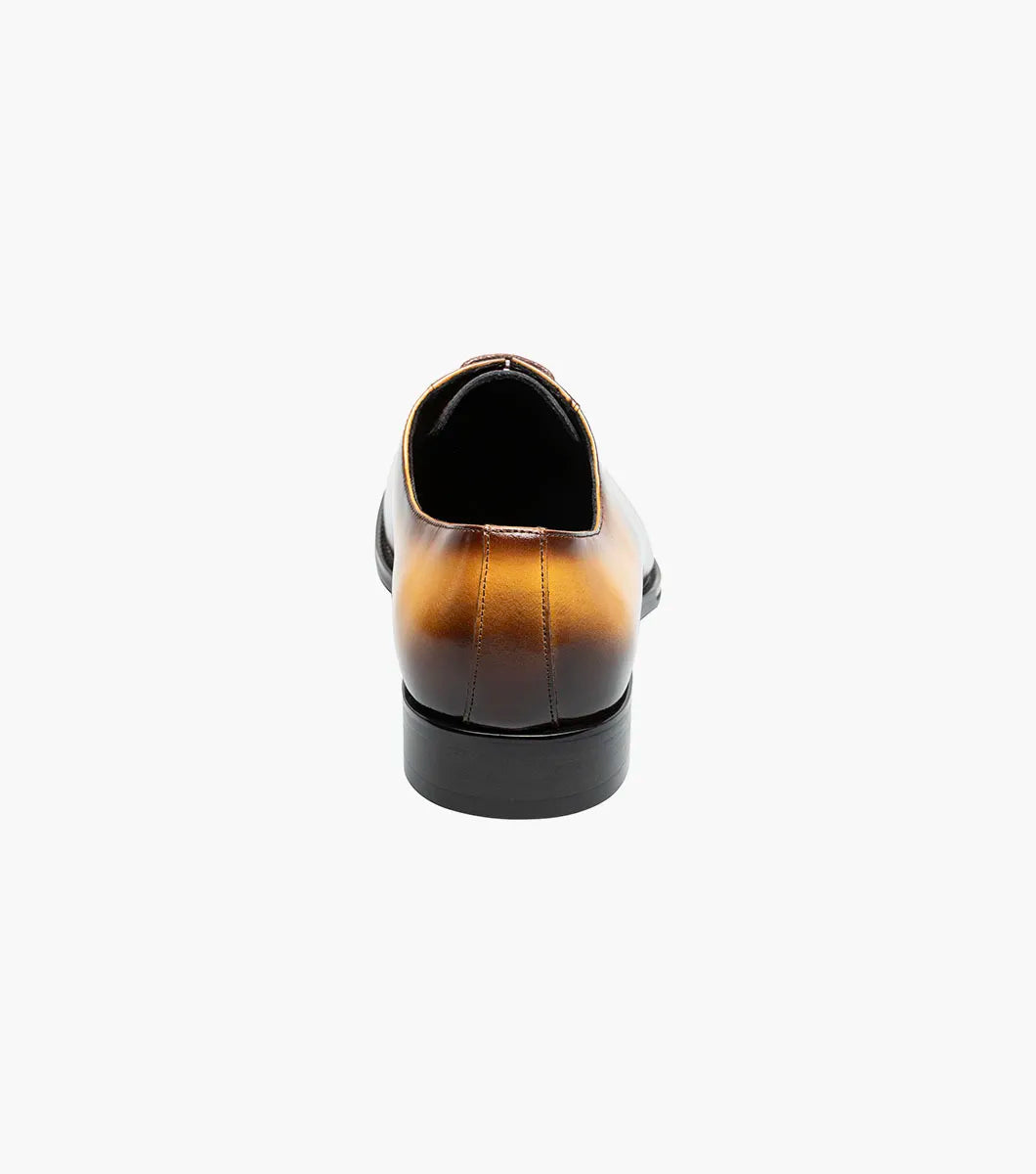 The STACY ADAMS Shaffer Plain Toe Oxford in Cognac Multi (25763-229) features calf leather with a brown-yellow gradient, laces, a low heel, memory foam insole, and polished finish, displayed on a white background.