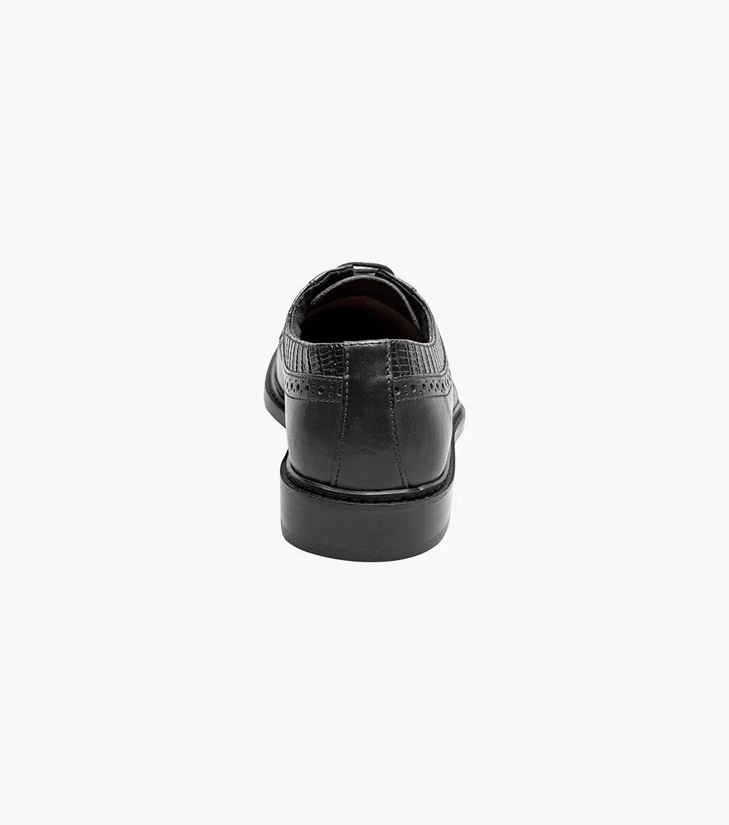 The Stacy Adams Gambetta Modified Cap Toe Oxford (25780-001) is a black leather dress shoe with textured detailing, lace-up closure, low heel, and RedZone footbed, shown on a plain white background.