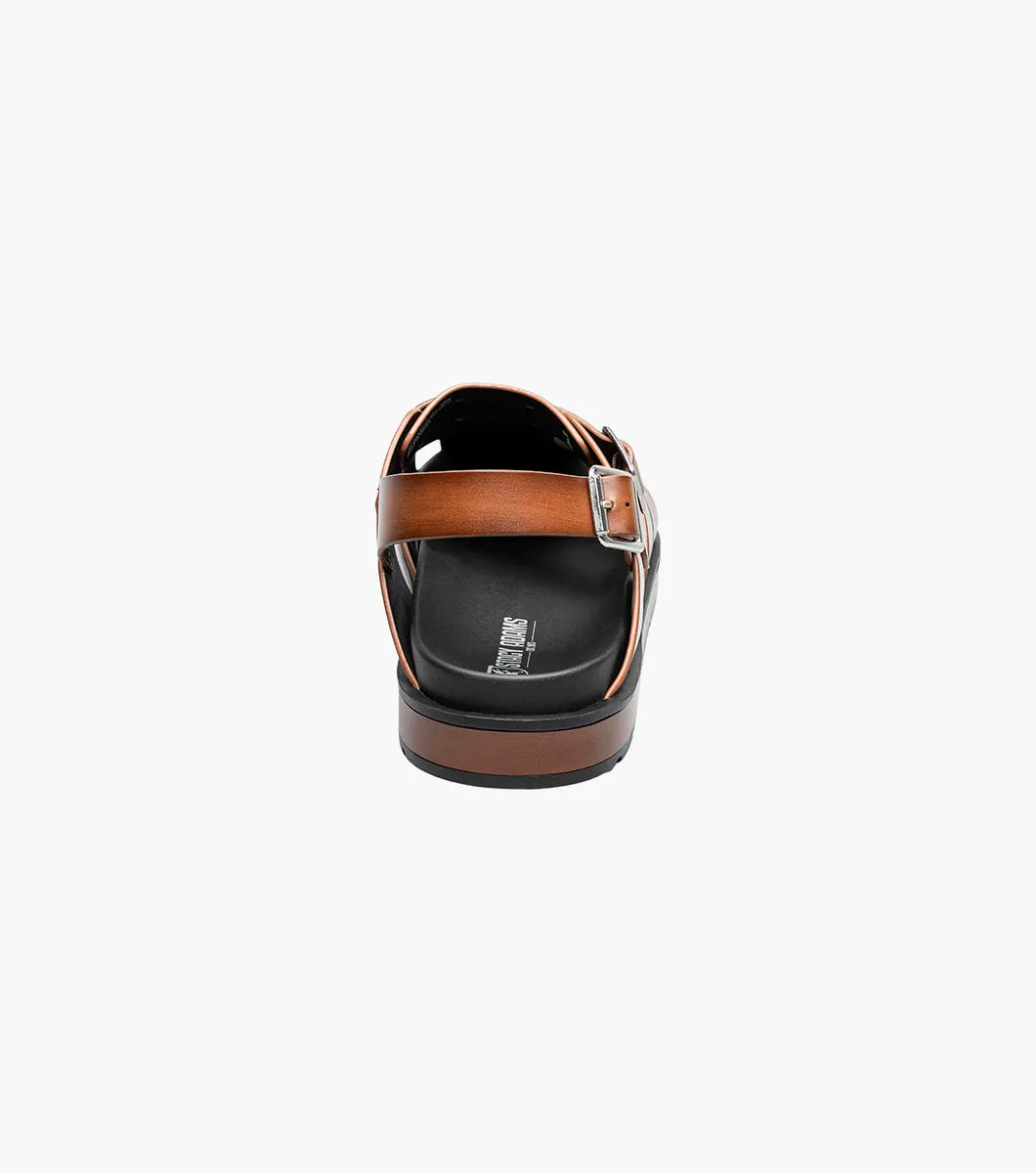 The STACY ADAMS Largo Slingback Buckle Sandal in cognac features a closed toe, woven leather upper, adjustable side buckle, and cushioned black sole—perfect men’s summer footwear. Shown here in style 25773-221 on a white background.