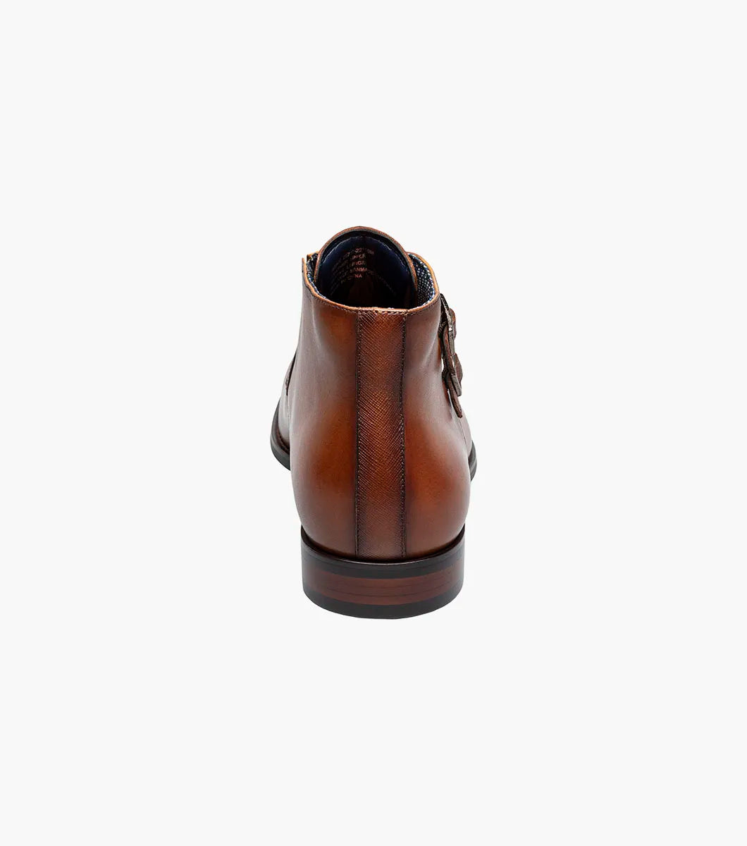 The STACY ADAMS Kaius Plain Toe Double Monk Strap Boot in Cognac (25733-221) features hand-burnished leather, a textured side panel, low stacked heel, and anatomical arch support, shown on a white background.