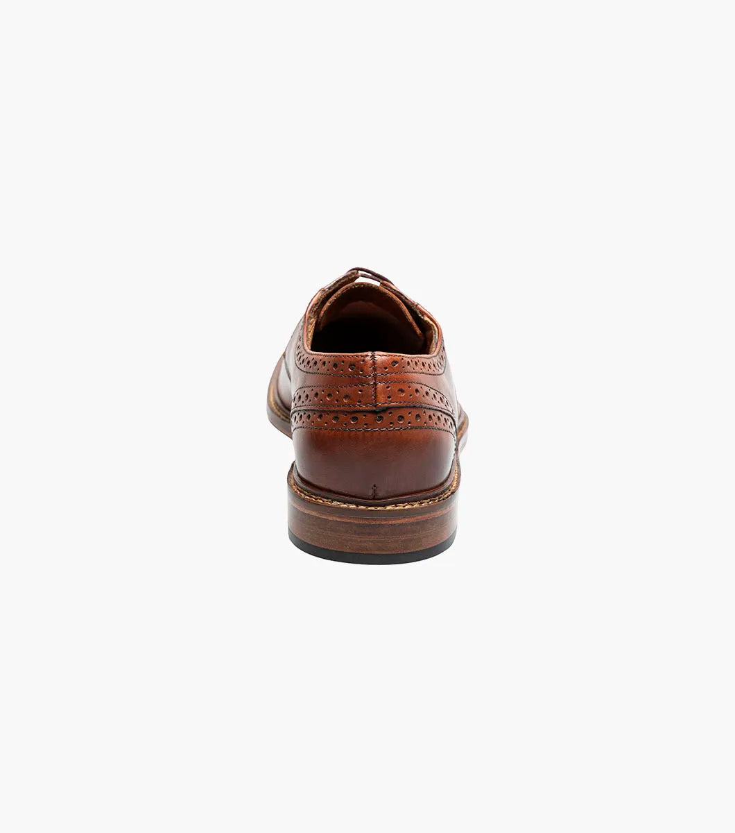 The Stacy Adams Giorgetti Plain Toe Oxford in Cognac features lizard print leather, brogue details, textured accents, a cushioned footbed, low heel, and lace-up closure.
