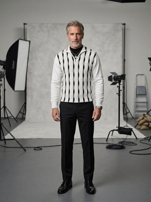A man with gray hair stands in a photography studio wearing the Suslo Couture Half Zip Sweater FP203 from Unique Design Menswear, paired elegantly with black pants and black shoes. Studio lights, a ladder, and a backdrop set the scene, enhancing his refined approach to men’s fashion.