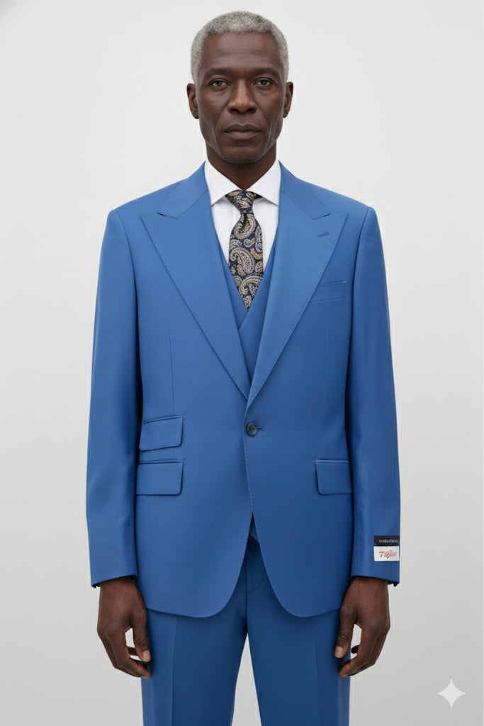 A man wearing the Tiglio Rosso Orvietto Azure Semi Wide Leg TL7118 three piece suit by Tiglio Rosso, paired with a white shirt and patterned tie, stands facing forward against a plain light background.