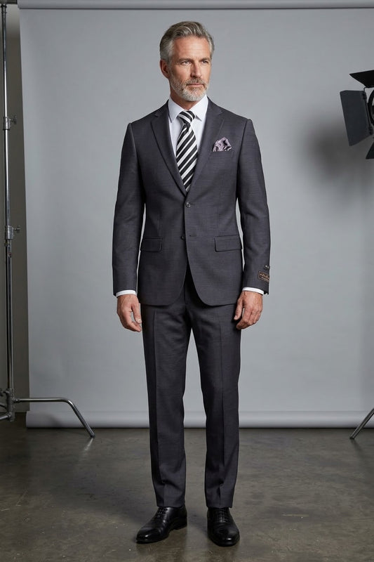 The Tiglio Luxe Novello Medium Gray Pure Wool Men’s Suit TIG1008 features a white dress shirt, striped tie, blue flower lapel pin, and a left sleeve label—Tiglio Luxe luxury fashion for men, displayed on a headless mannequin.