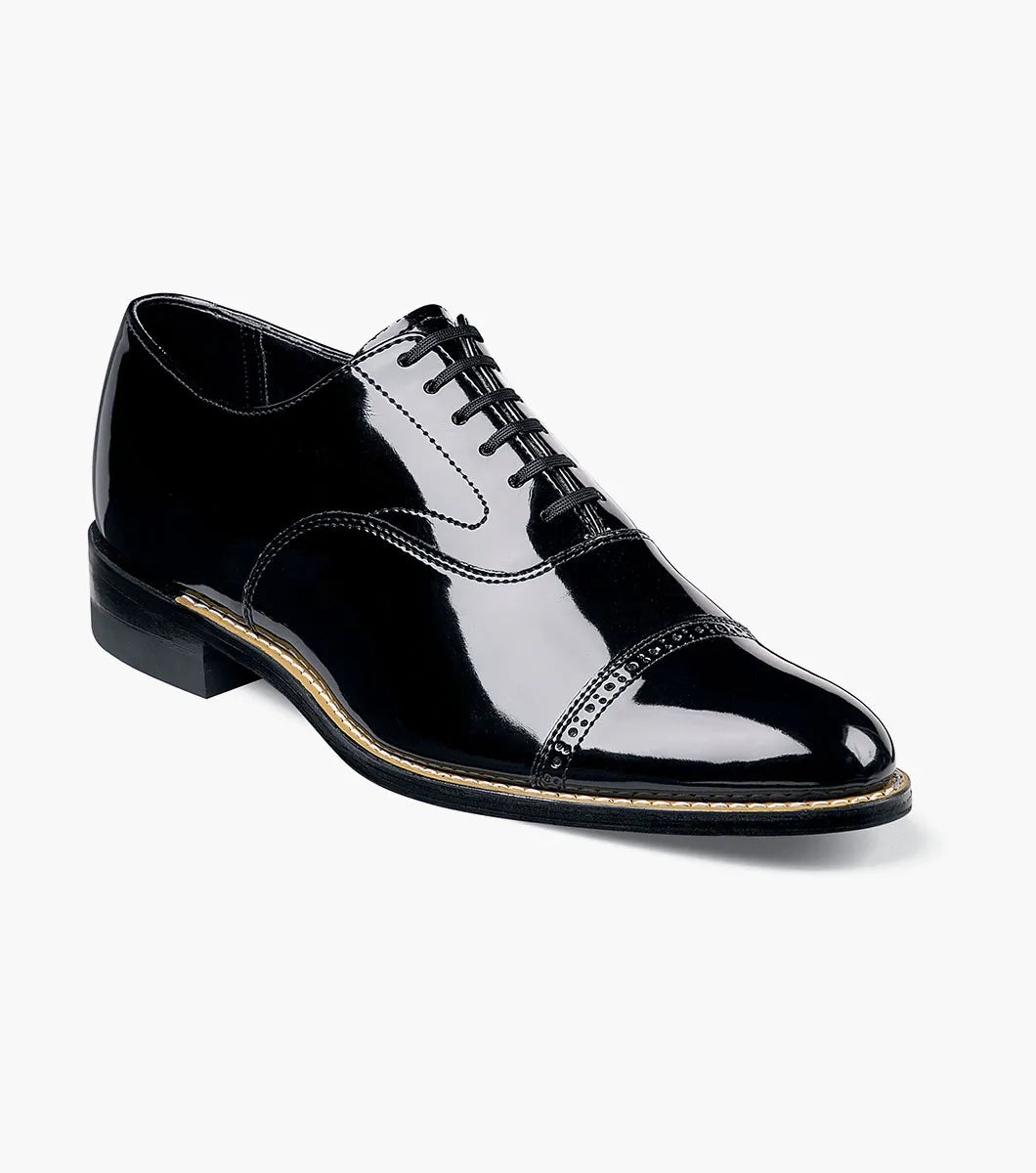 The Stacy Adams Concorde Cap Toe Oxford (Style 11003-01) features a black patent leather upper, cap toe, black laces, low heel, and stitching detail. Shown in side profile against a white background. Brand: STACY ADAMS.