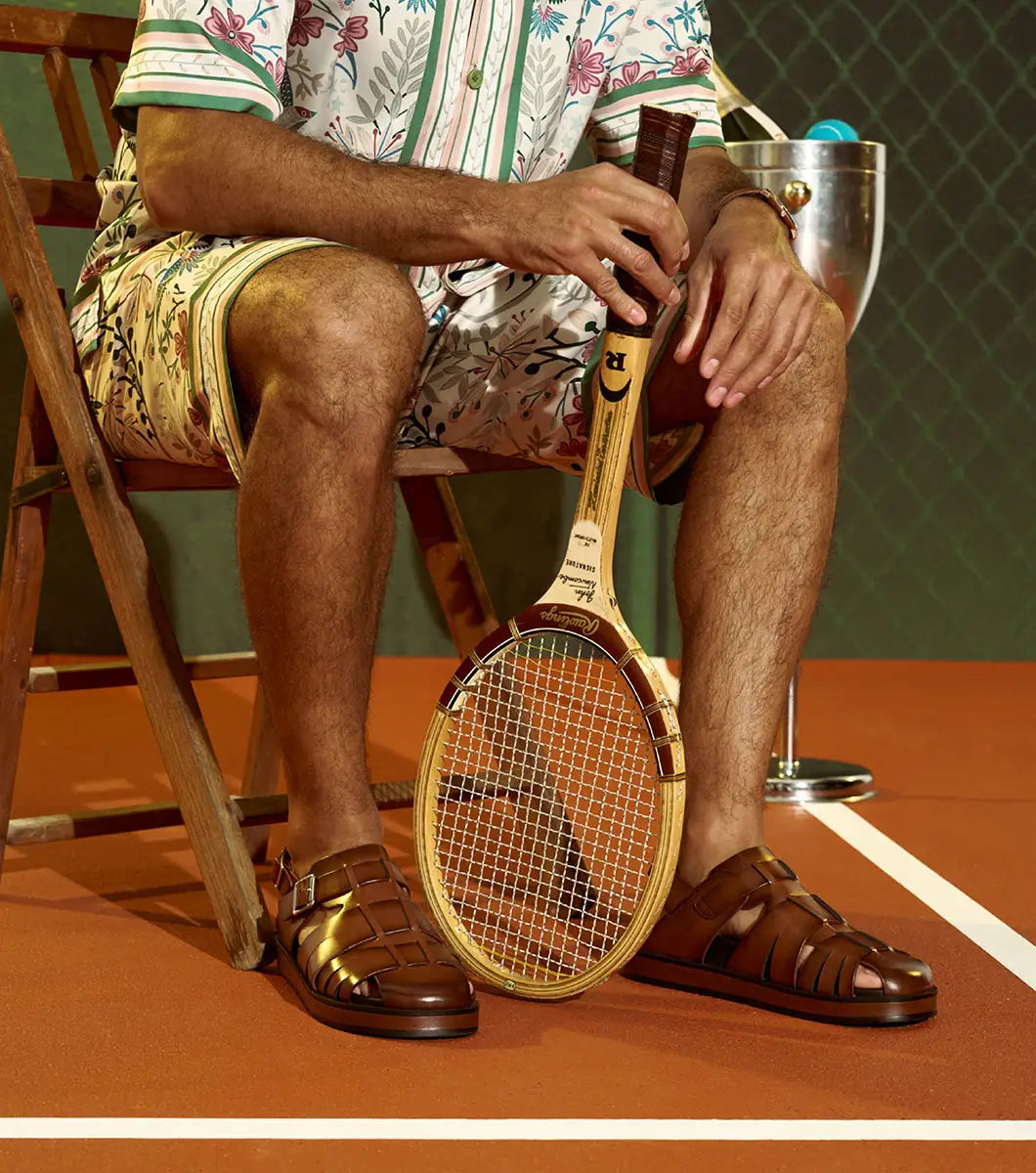 The STACY ADAMS Largo Slingback Buckle Sandal in cognac features a closed toe, woven leather upper, adjustable side buckle, and cushioned black sole—perfect men’s summer footwear. Shown here in style 25773-221 on a white background.