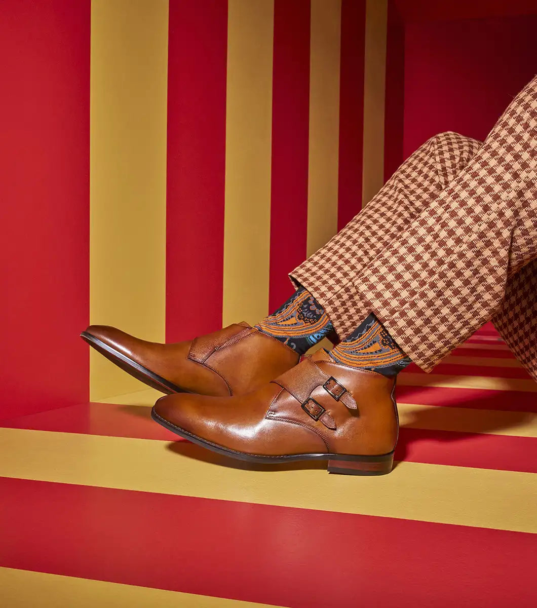 The STACY ADAMS Kaius Plain Toe Double Monk Strap Boot in Cognac (25733-221) features hand-burnished leather, a textured side panel, low stacked heel, and anatomical arch support, shown on a white background.
