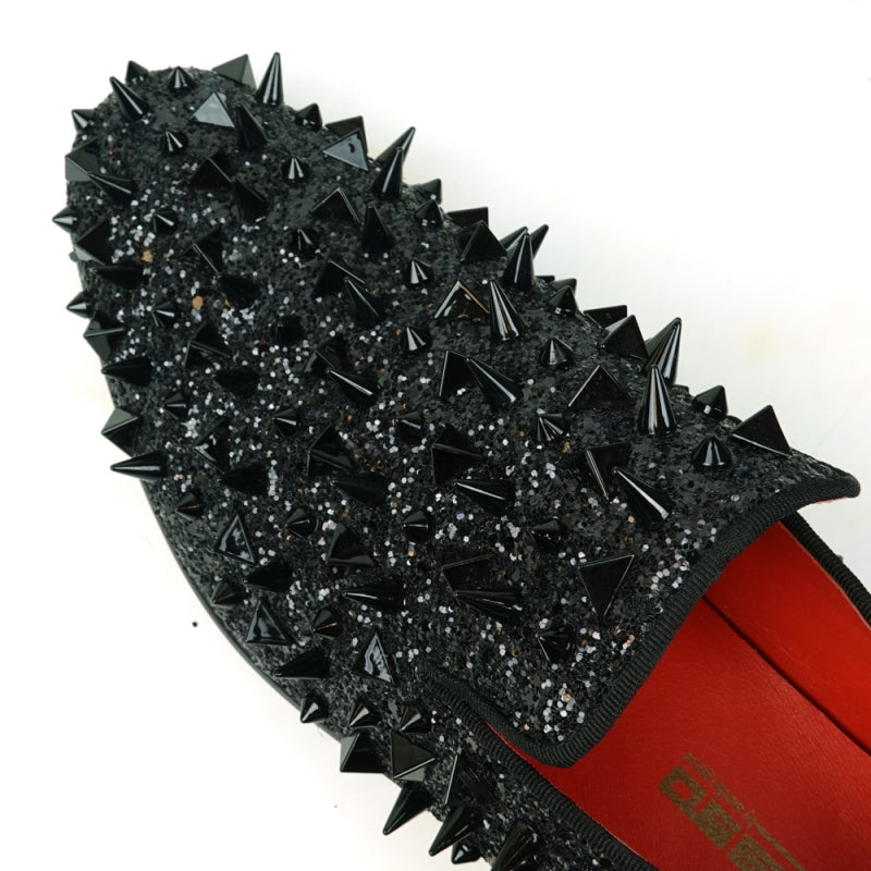 The FI-7517 Black Glitter Black Spikes Slip On Loafer by Fiesso is a striking masterpiece, adorned with black spikes and glitter, featuring a luxurious red interior lining. This exquisite shoe boasts a leather upper that promises both elegance and durability.