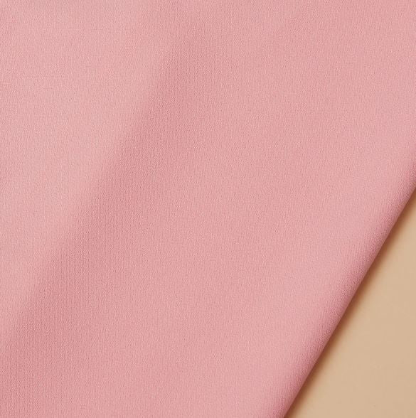 The Inserch 2pc Set (Shirts and Pants) Summer Pink by Inserch is draped diagonally over a beige background, showcasing its pink microfiber-like fabric.