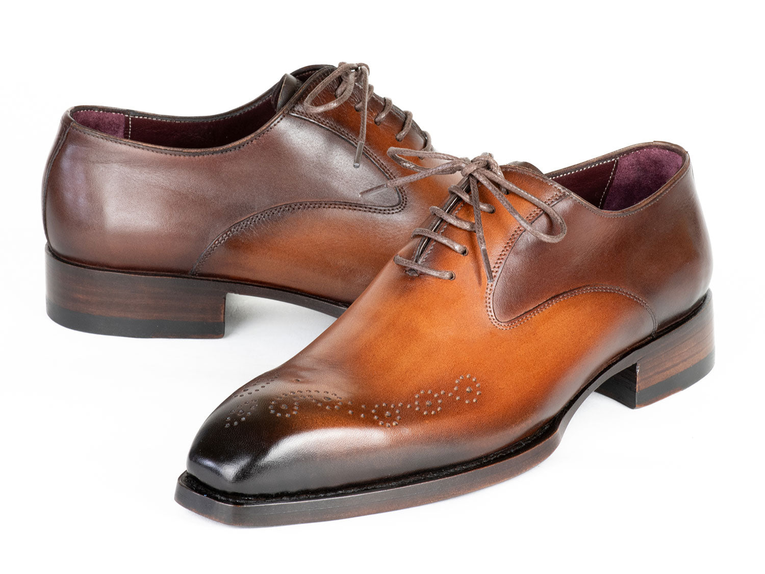 The Paul Parkman Goodyear Welted Punched Oxfords Brown & Camel - 5364-BRC are expertly crafted dress shoes featuring decorative perforations, a polished finish, and laces. Made-to-order by Paul Parkman, these shoes offer a durable Goodyear welted construction and timeless style.
