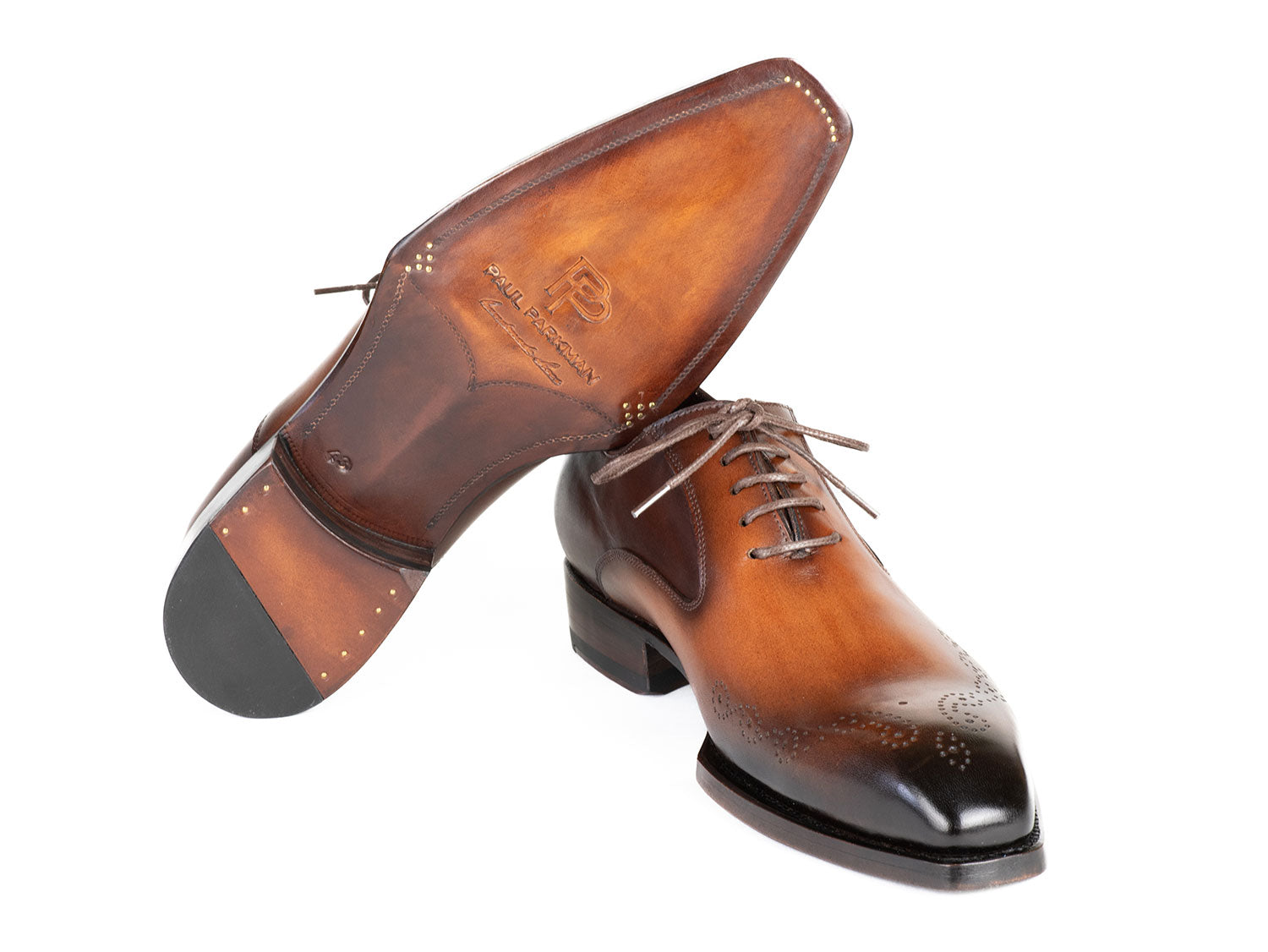 The Paul Parkman Goodyear Welted Punched Oxfords Brown & Camel - 5364-BRC are expertly crafted dress shoes featuring decorative perforations, a polished finish, and laces. Made-to-order by Paul Parkman, these shoes offer a durable Goodyear welted construction and timeless style.