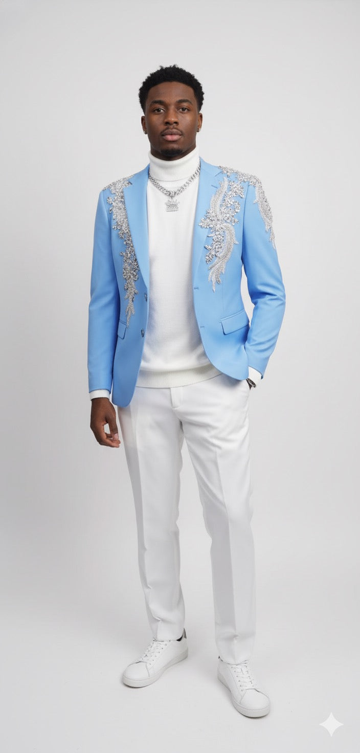 A man stands against a plain background wearing the Unique Design Menswear Custom Prom Suit Light Blue with Silver Rhinestones, paired with a white turtleneck, white pants, and white sneakers.
