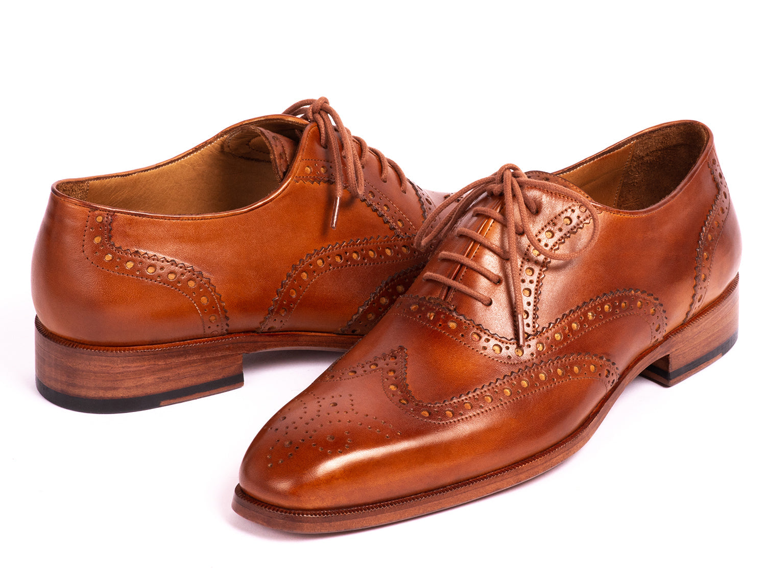 The Paul Parkman Wingtip Oxfords Mid Brown - 5447-BRW are brown hand-painted leather brogues with decorative perforations and laces, displayed against a white background.
