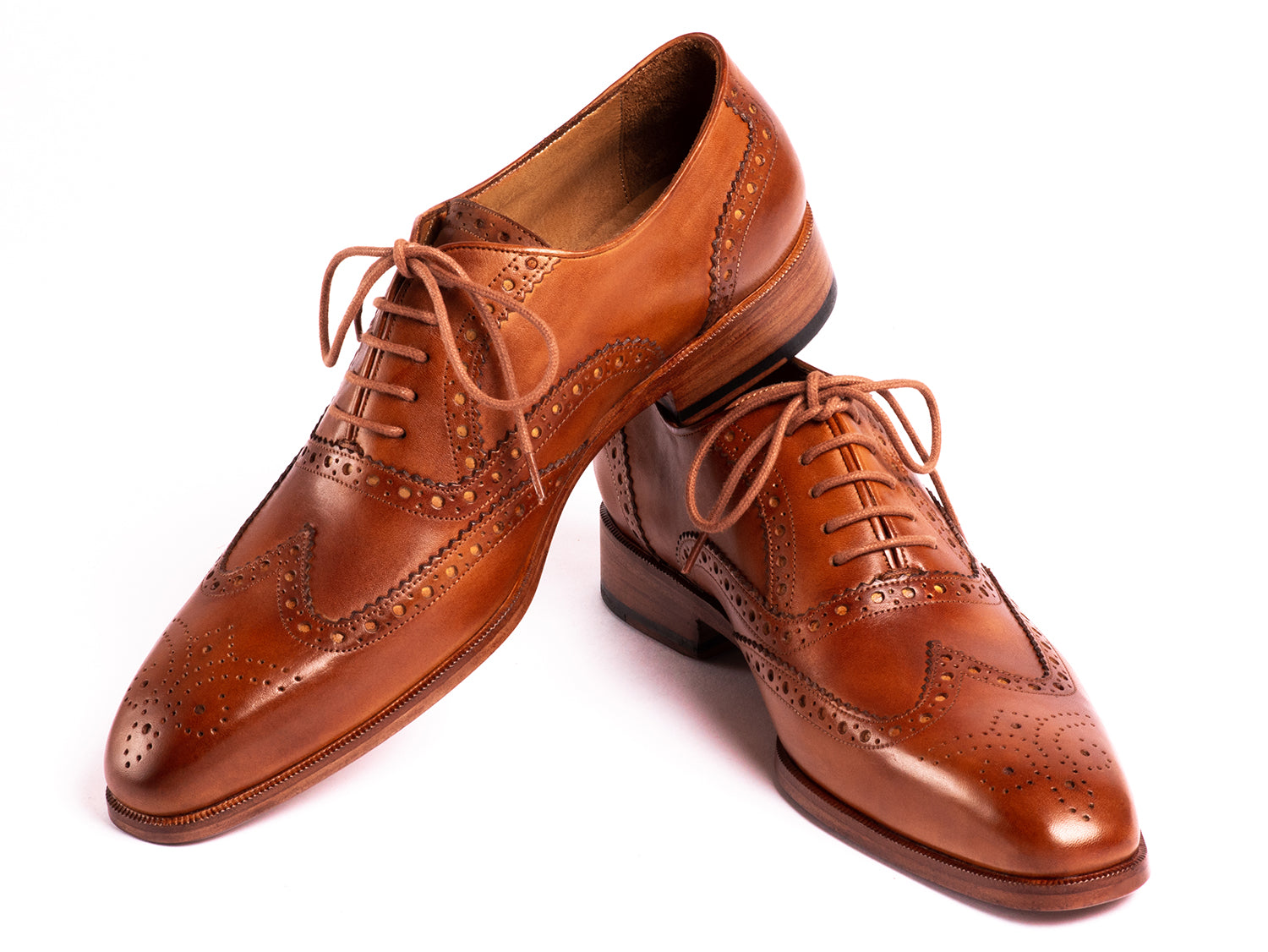 The Paul Parkman Wingtip Oxfords Mid Brown - 5447-BRW are brown hand-painted leather brogues with decorative perforations and laces, displayed against a white background.
