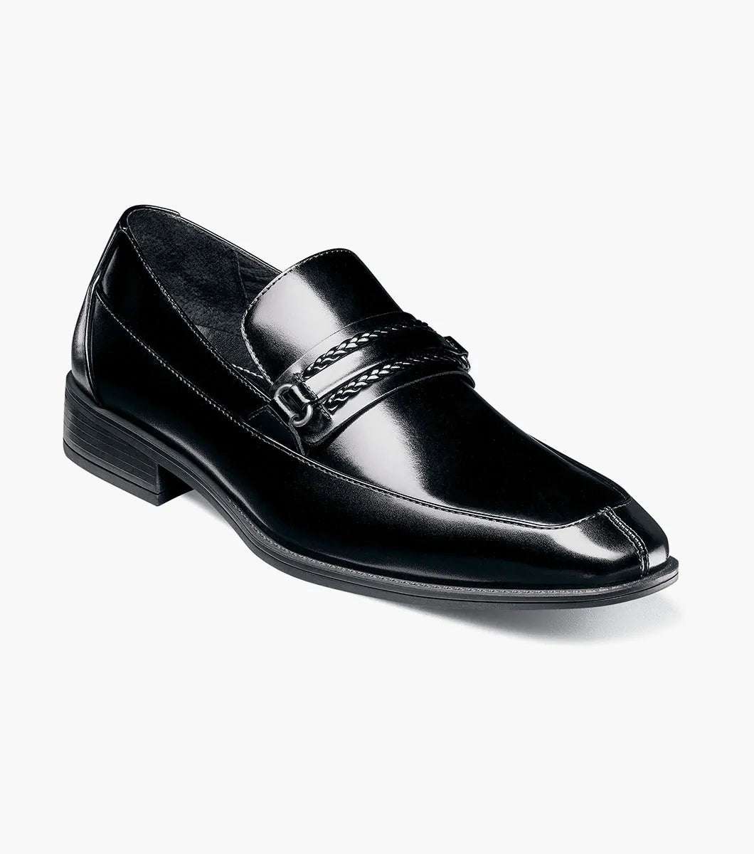 The Stacy Adams Aberdeen Moc Toe Saddle Slip On (20203-001) is a black dress loafer with a leather upper, low heel, square toe, and braided strap detail across the upper.