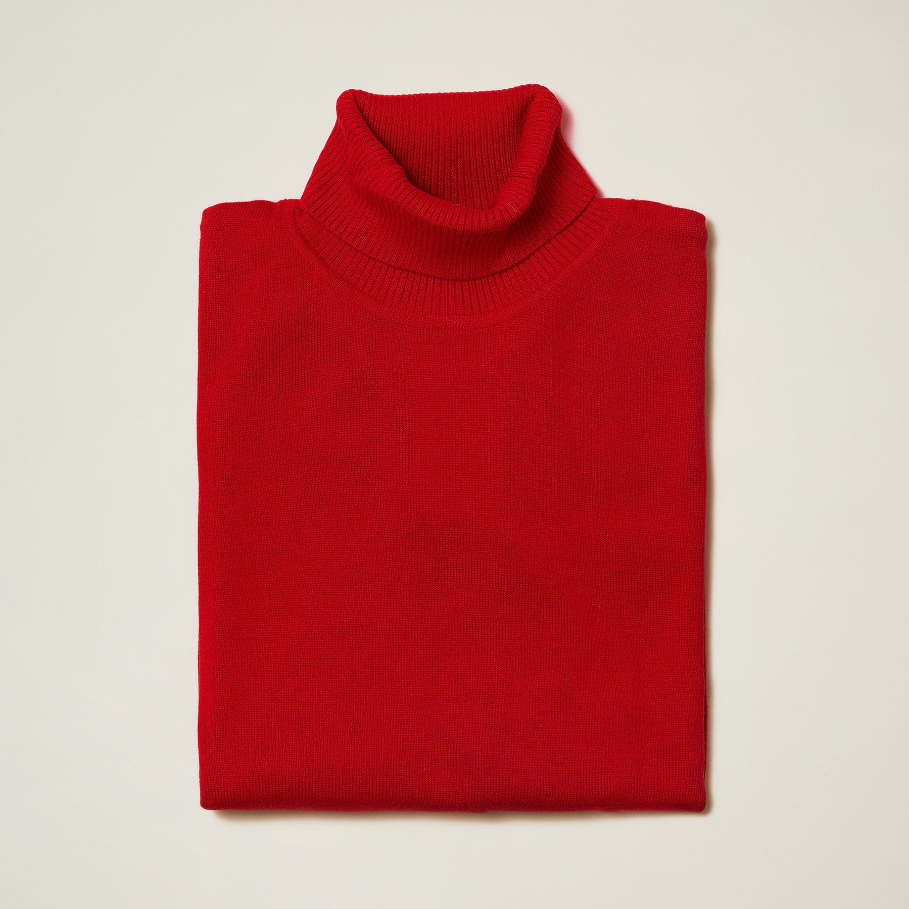 The Inserch Cotton Blend Turtleneck Sweater Red 4708 by Inserch, known for its soft cotton blend, is neatly folded on a light surface, delivering a refined appearance.