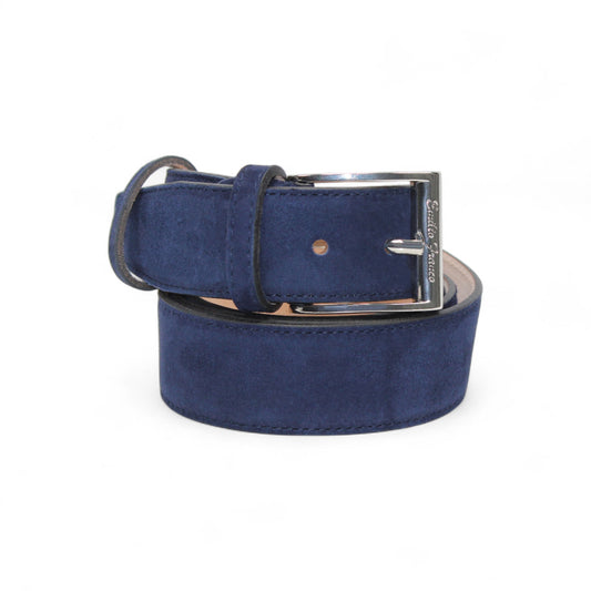 The handcrafted Matiste Navy Suede Belt 202 by Matiste, featuring a silver buckle, is shown rolled up against a plain white background.