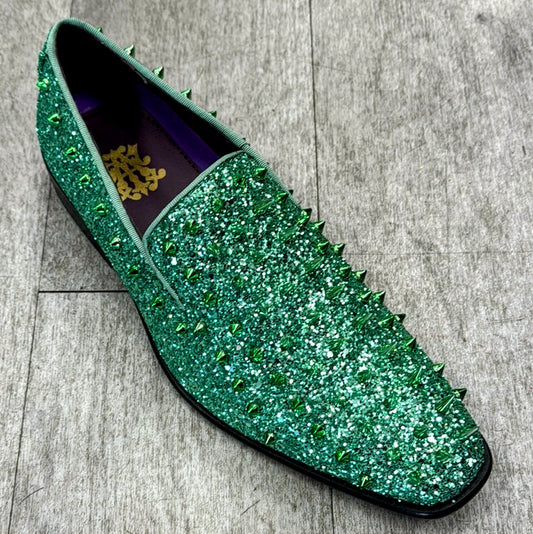 The Exclusive Formal Dress Shoe Green 6788, by UNIQUE DESIGN MENSWEAR, crafted from genuine suede leather and adorned with spikes, rests elegantly on a gray wooden floor.