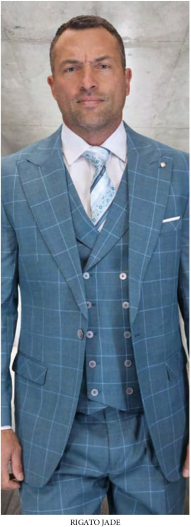 A man stands before a gray background wearing Statement Clothing's STATEMENT CLOTHING | RIGATO-JADE—a blue checkered three-piece suit with pleated pants, a white shirt, and a patterned tie.