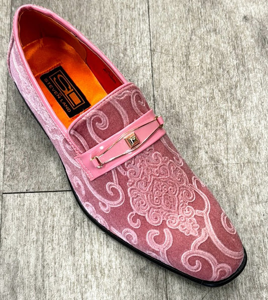 The Exclusive Formal Dress Shoe Pink Paisley with Buckle SL0096 by UNIQUE DESIGN MENSWEAR, featuring intricate embroidery and a decorative pink strap, crafted from genuine suede leather, sits elegantly on a light wood floor.