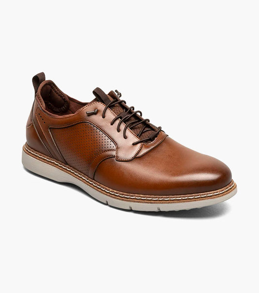 The Stacy Adams Score Plain Toe Elastic Lace Up in Cognac (21538-221) features brown leather with perforated side detailing, elastic laces, and a white rubber sole. Enhanced with a RedZone footbed for superior support and all-day comfort, this STACY ADAMS shoe is displayed against a plain white background.