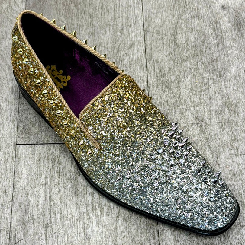 A single Exclusive Formal Dress Shoe Gold / Silver 6860, featuring a glittery gradient design from gold to silver and adorned with metallic spikes, crafted from genuine leather by UNIQUE DESIGN MENSWEAR. It is displayed on a textured gray surface, reflecting the elegance of Italian craftsmanship.